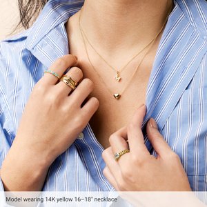 Model wearing a puffed heart necklace in 14K yellow gold