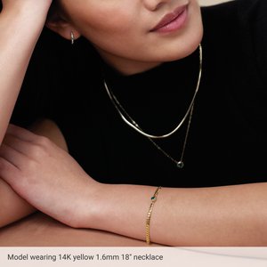 Model wearing an 18 inch 1.6 mm herringbone chain necklace in 14K yellow gold