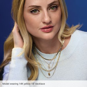 Model wearing an engravable puffed dog tag necklace in 14K yellow gold